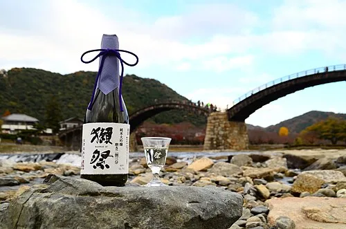 긴타이교를 배경으로 놓인 닷사이 23 병과 잔